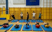 10 Personen in der Sporthalle. Fünf befinden sich mit Bauchtraining auf der Matte. Die anderen sind mit Schlingentraining beschäftigt.