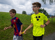 Jugendlicher Teilnehmer (blind) mit sehenden Jugendlichen als Begleitsportler beim Laufen